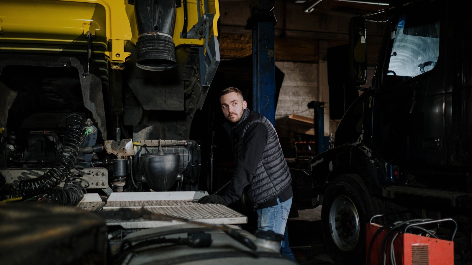 A technician working a late shift on a piece of heavy equipment under a worklight